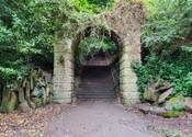 Archway entrance to Armley Killer Steps. Surrounded by trees.